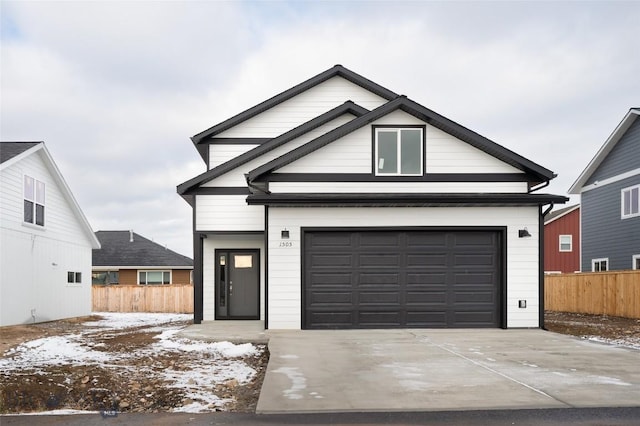 view of front of house with a garage, driveway, and fence