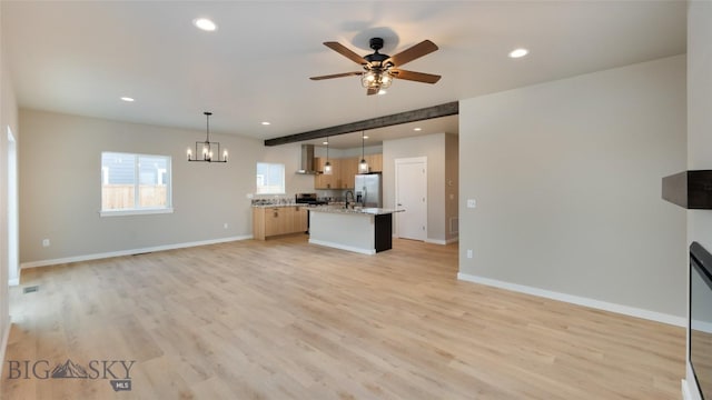 unfurnished living room with beam ceiling, ceiling fan with notable chandelier, and light hardwood / wood-style flooring