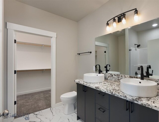 bathroom featuring toilet, a shower, and vanity