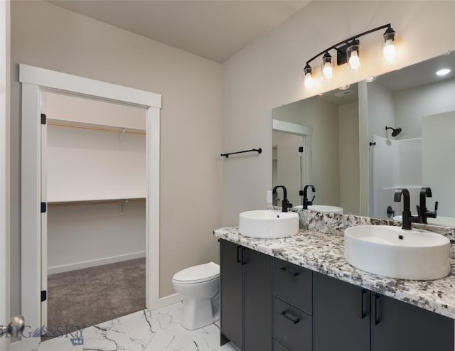 full bathroom featuring marble finish floor, a spacious closet, walk in shower, and a sink