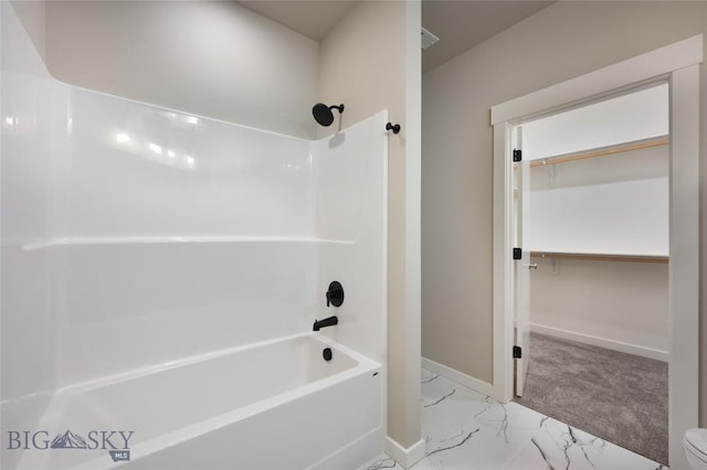 full bath featuring marble finish floor, shower / tub combination, a spacious closet, and baseboards