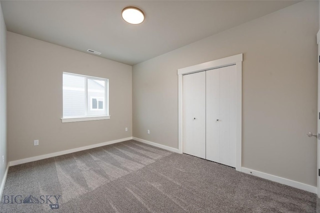 unfurnished bedroom featuring carpet, a closet, visible vents, and baseboards