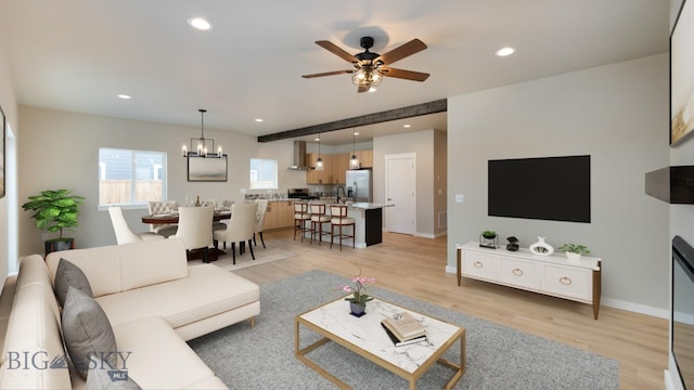 living area with light wood-style flooring, ceiling fan with notable chandelier, baseboards, and recessed lighting