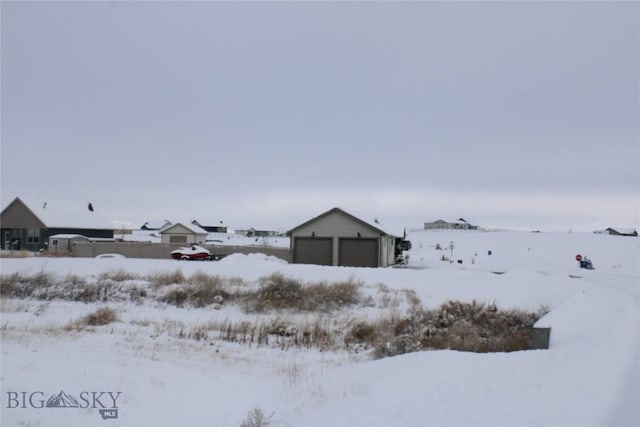 snowy yard with an outbuilding and a garage