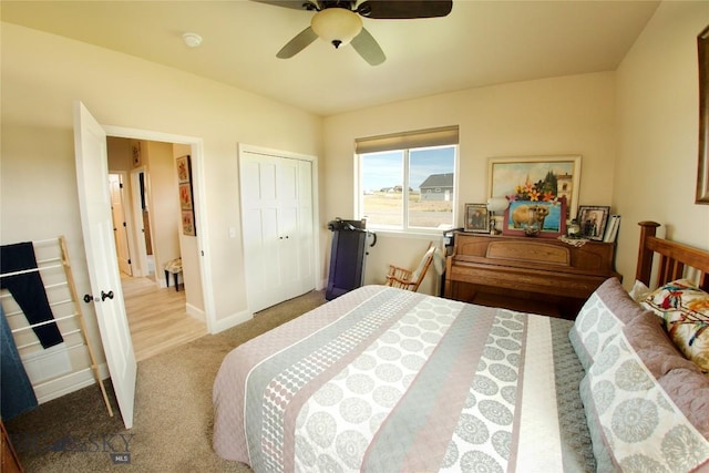 bedroom with baseboards, a closet, a ceiling fan, and light colored carpet