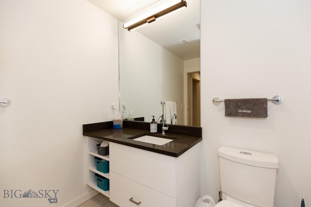 bathroom with tile patterned flooring, vanity, and toilet