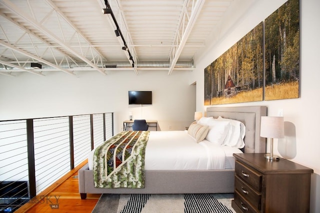 bedroom featuring wood-type flooring and rail lighting