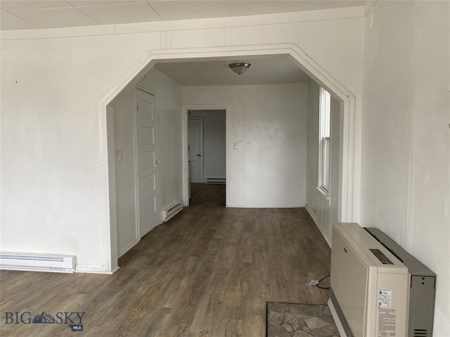 additional living space featuring dark hardwood / wood-style floors and baseboard heating