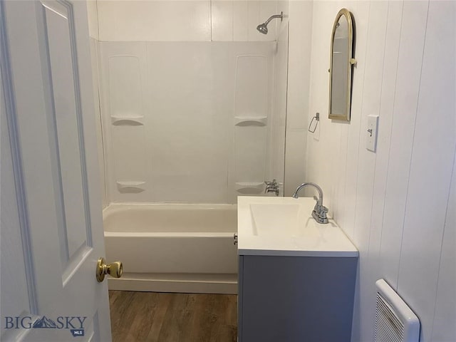 bathroom featuring wood-type flooring, vanity, and shower / tub combination