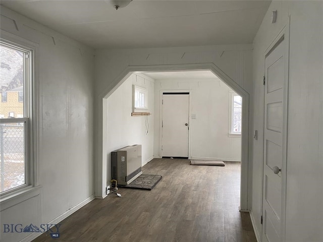 interior space with heating unit and dark wood-type flooring