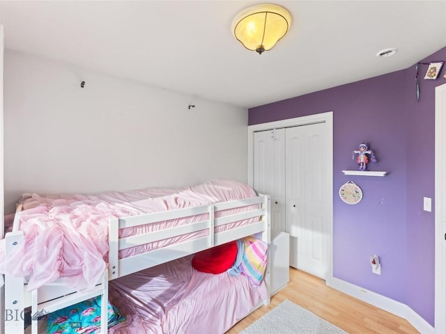 bedroom with light hardwood / wood-style flooring and a closet