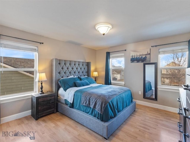 bedroom with multiple windows and light hardwood / wood-style floors