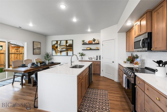 kitchen with sink, hardwood / wood-style floors, a center island with sink, and appliances with stainless steel finishes