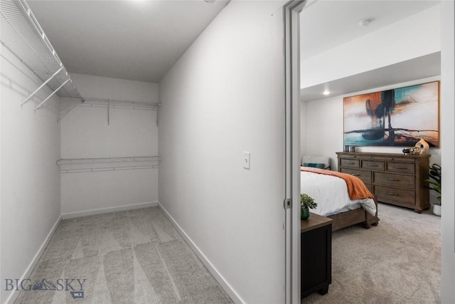 walk in closet featuring light colored carpet