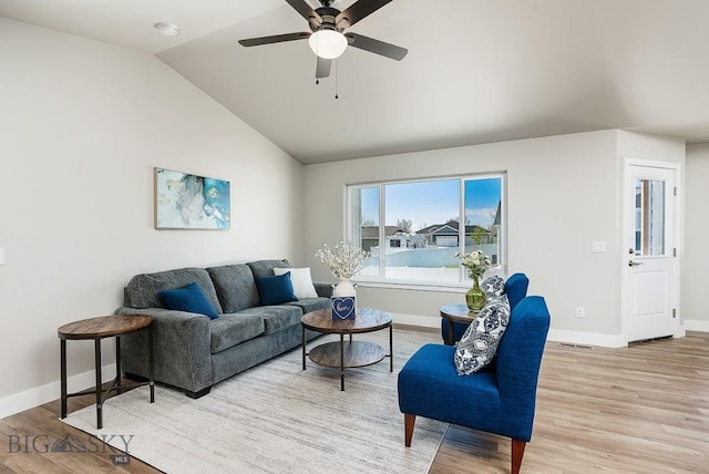 living room featuring ceiling fan, light hardwood / wood-style flooring, and lofted ceiling