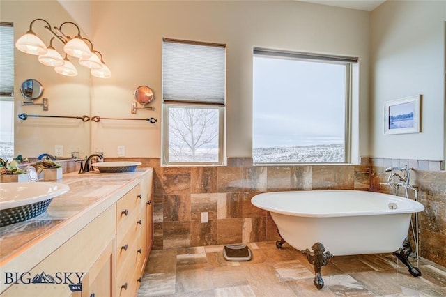 1061 Lookabout Ln, Manhattan, MT 59741 - full bathroom featuring tile walls, a freestanding tub, double vanity, and wainscoting
