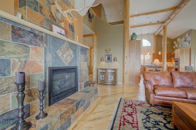 1061 Lookabout Ln, Manhattan, MT 59741 - living room with wood finished floors, high vaulted ceiling, beam ceiling, a tiled fireplace, and recessed lighting