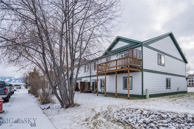 snow covered property featuring a wooden deck