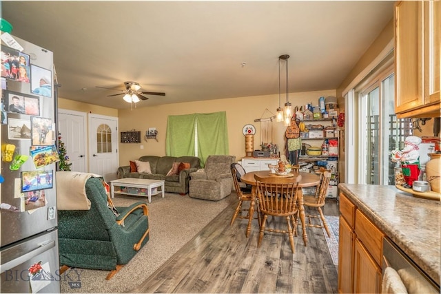 dining space featuring ceiling fan with notable chandelier and dark hardwood / wood-style flooring