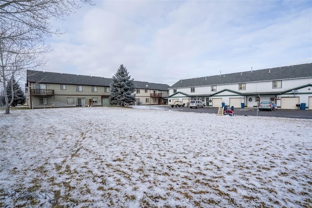 snow covered rear of property with a garage