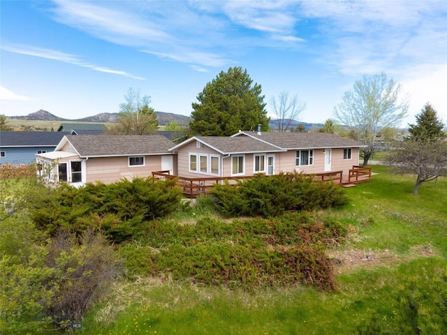 rear view of property featuring a deck with mountain view