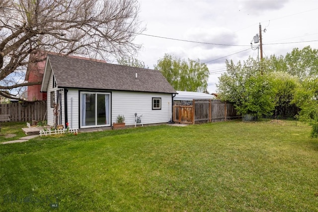 back of property featuring a yard and an outdoor structure