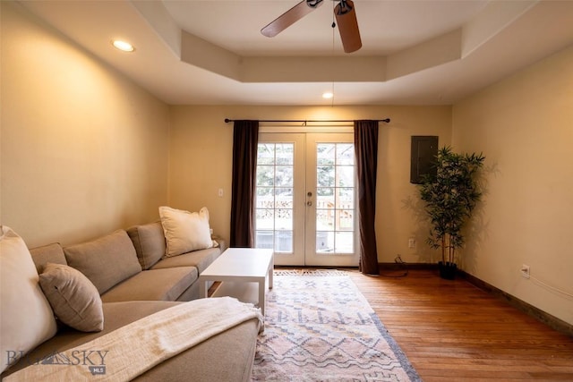 living room with a raised ceiling, ceiling fan, french doors, and hardwood / wood-style flooring