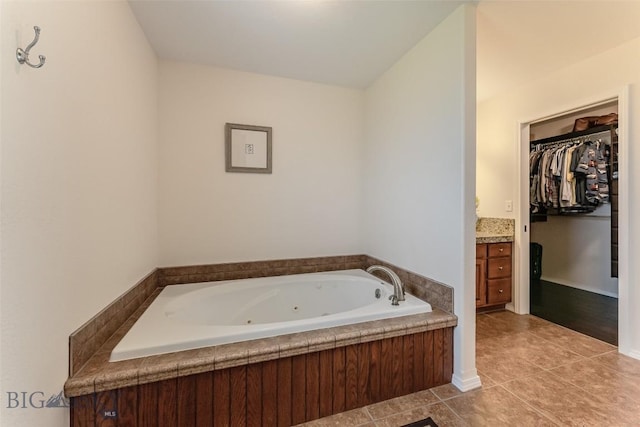 bathroom with tile patterned flooring, vanity, and a tub