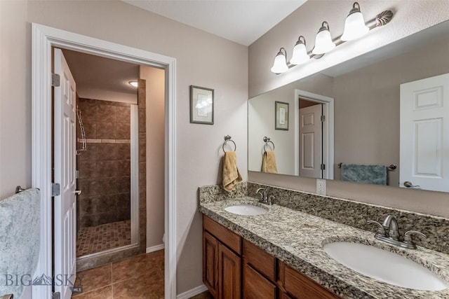 bathroom featuring tile patterned flooring, vanity, and tiled shower