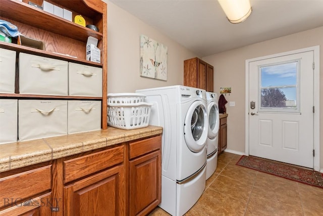 laundry room with washer and clothes dryer, light tile patterned flooring, and cabinets