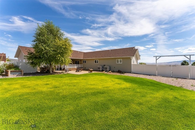 rear view of house with a yard and a patio