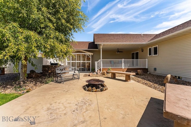 rear view of property featuring ceiling fan, a patio area, and an outdoor fire pit