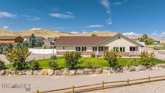 rear view of property with a mountain view and a yard