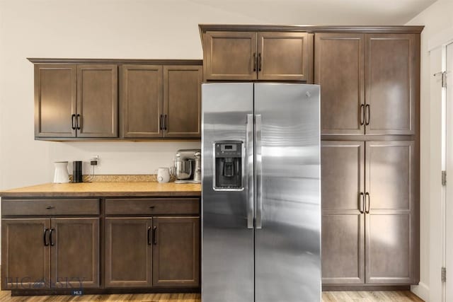 kitchen featuring light hardwood / wood-style floors, dark brown cabinetry, and stainless steel refrigerator with ice dispenser