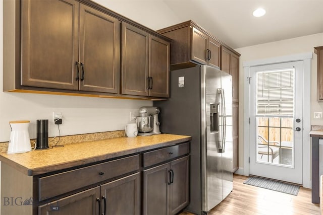 kitchen with light wood-type flooring, stainless steel refrigerator with ice dispenser, and dark brown cabinetry