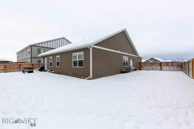 view of snow covered back of property