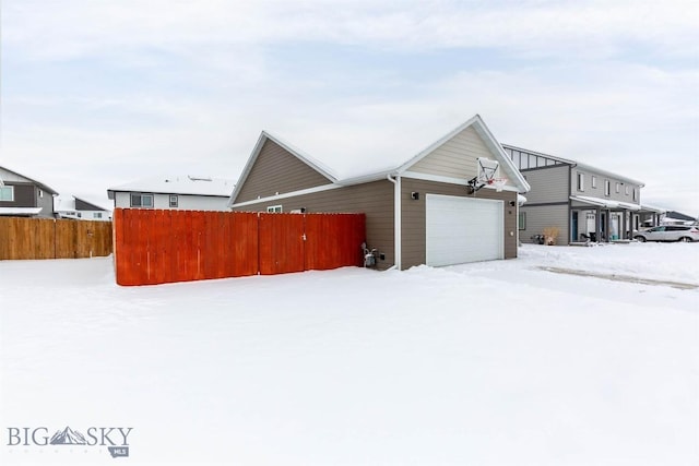 view of snowy exterior featuring a garage