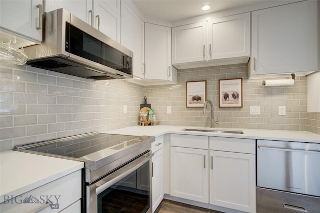 kitchen featuring decorative backsplash, appliances with stainless steel finishes, white cabinetry, and sink