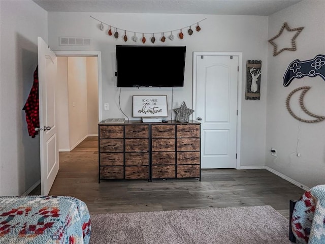 bedroom with dark hardwood / wood-style flooring