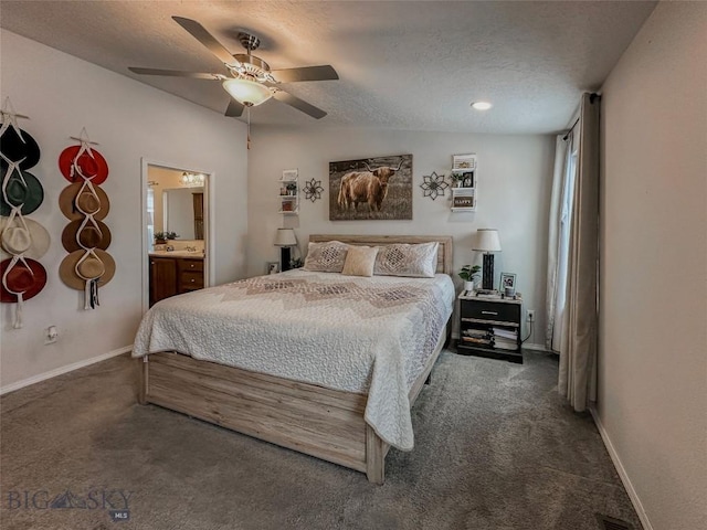 carpeted bedroom with ceiling fan, ensuite bathroom, and a textured ceiling