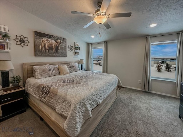 carpeted bedroom featuring multiple windows, ceiling fan, and a textured ceiling