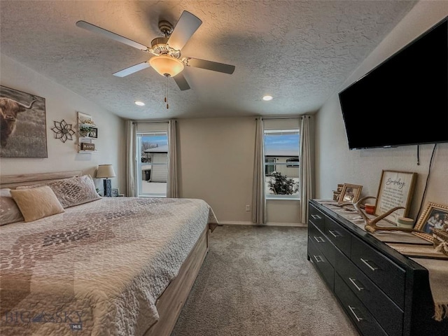 bedroom featuring light colored carpet, a textured ceiling, and ceiling fan