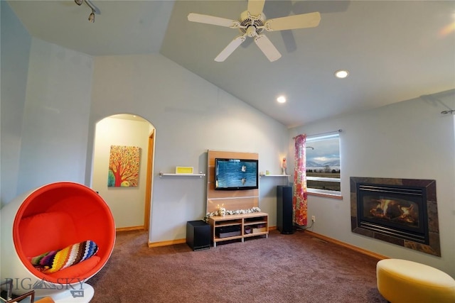 living room with ceiling fan, lofted ceiling, carpet floors, and a tile fireplace