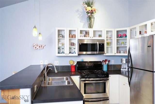 kitchen featuring white cabinets, decorative light fixtures, sink, and appliances with stainless steel finishes