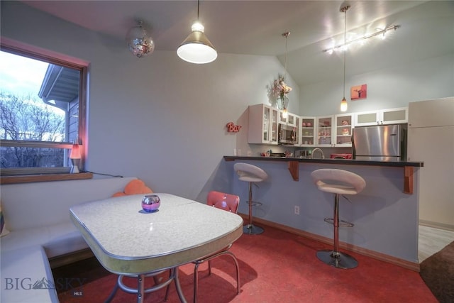 dining area with sink and vaulted ceiling