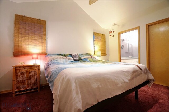 carpeted bedroom featuring connected bathroom and vaulted ceiling