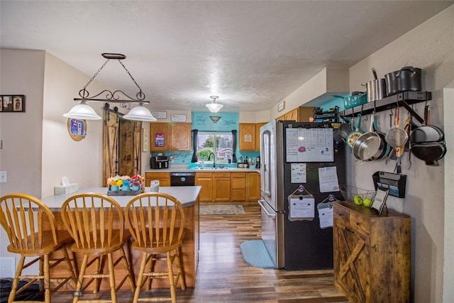 kitchen with stainless steel refrigerator, dishwasher, sink, wood-type flooring, and a textured ceiling