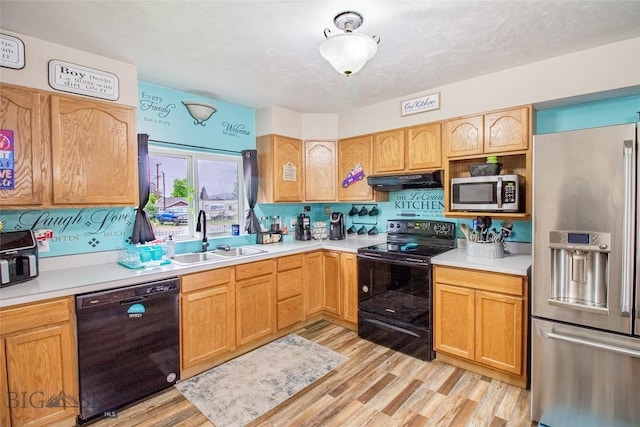 kitchen with black appliances, light hardwood / wood-style floors, sink, and tasteful backsplash