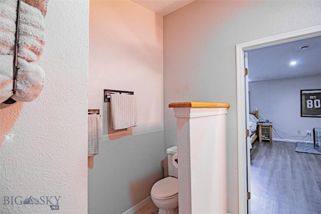 bathroom featuring hardwood / wood-style floors and toilet