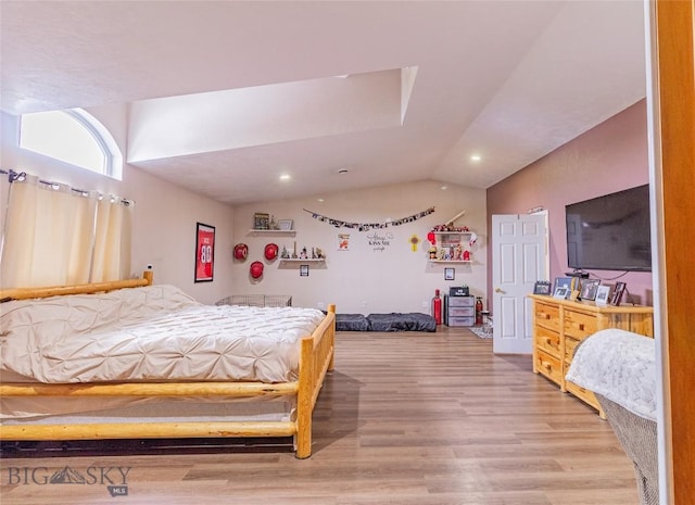 bedroom featuring light hardwood / wood-style flooring and lofted ceiling